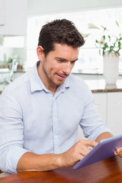 Hombre relajado concentrado usando tableta digital en la cocina —  Fotos de Stock