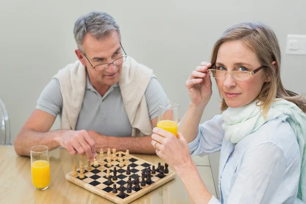 Pareja jugando al ajedrez mientras jugo de naranja — Stockfoto