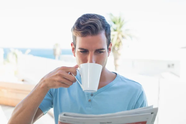Man drinking coffee and reading newspaper — Stock Photo, Image