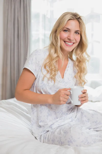 Hermosa mujer casual sosteniendo taza de café en la cama —  Fotos de Stock