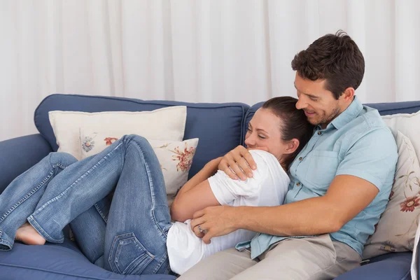 Loving young couple sitting on couch — Stock Photo, Image