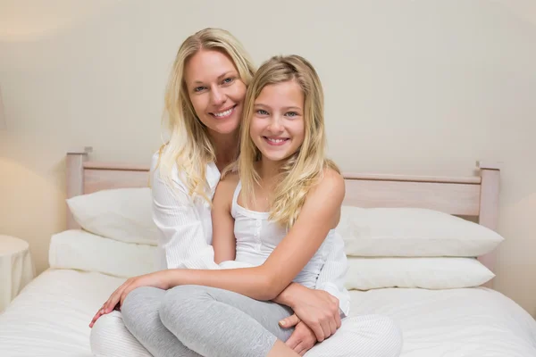 Mor och dotter sitter på sängen — Stockfoto