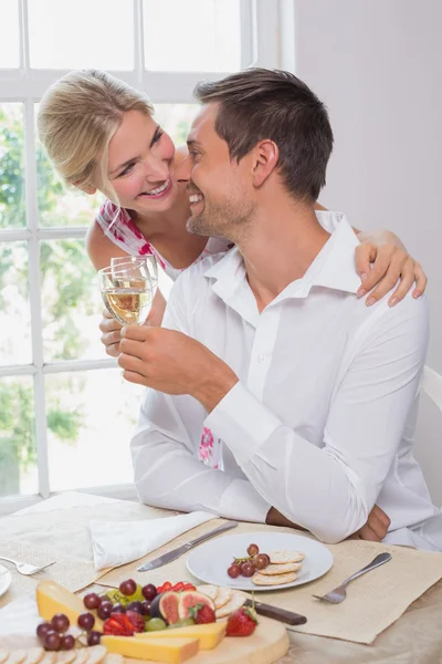 Heureux jeune couple avec des verres à vin ayant de la nourriture — Photo