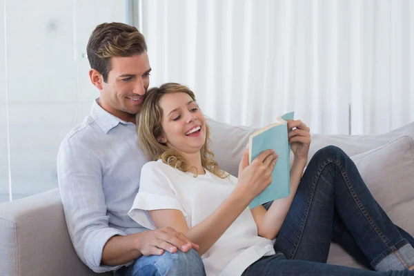 Livre de lecture couple détendu sur canapé — Photo