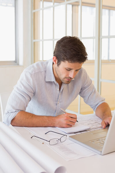 Businessman working on blueprints in office Stock Photo