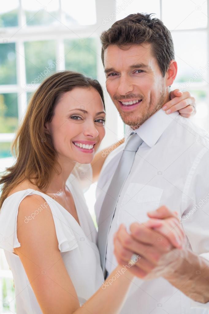 Happy loving couple dancing at home