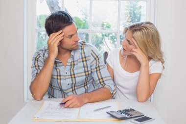 Worried couple with financial documents and calculator clipart