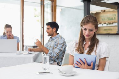 kahve dükkanında dijital tablet kullanan kadın