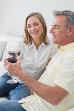 rahat çift kanepede oturan şarap bardakları ile