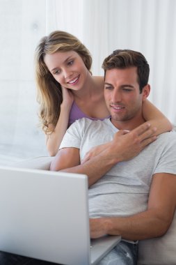 rahat çift kanepede dizüstü kullanarak