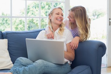 Anne ve kızı ile birbirine bakarak laptop