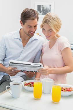 Çift evde kahvaltı yaparken gazete okuma