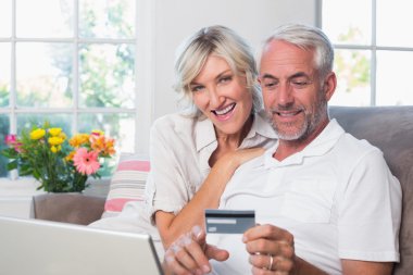 evde online alışveriş yaparken mutlu olgun çift