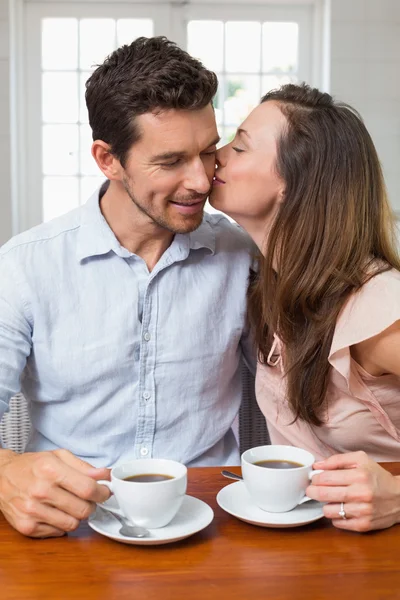 Loving couple with coffee cups at home — Stock Photo, Image