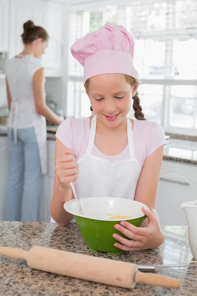 Girl helping her mother prepare food in kitchen — Stock Photo, Image