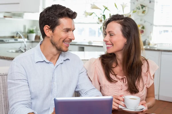 Couple utilisant une tablette numérique tout en prenant un café à la maison — Photo