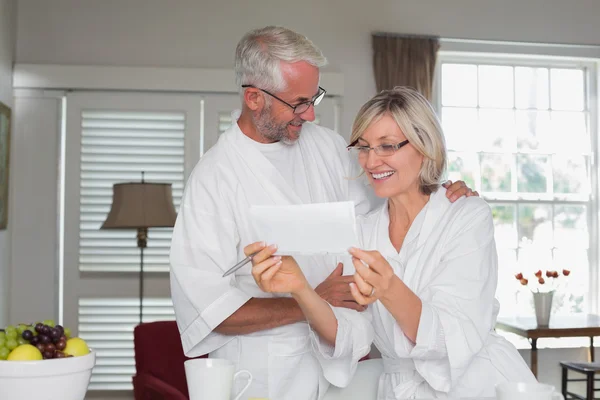 Mature couple looking at a document at home — Stock Photo, Image