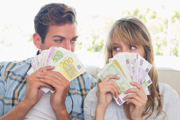 Gros plan d'un jeune couple tenant des billets en euros — Photo