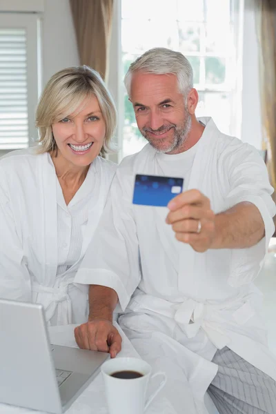 Ώριμο ζευγάρι αντέχοντας πιστωτική κάρτα στο σπίτι — Φωτογραφία Αρχείου