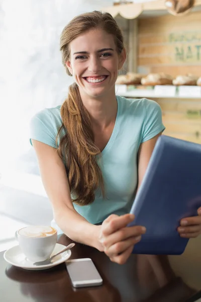 Mujer con taza de café usando tableta digital en la cafetería —  Fotos de Stock