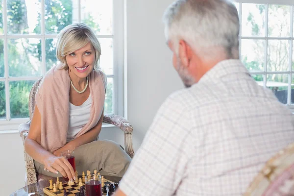 Пара, играющая в шахматы дома — стоковое фото