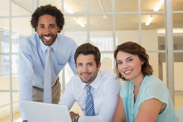 Drei Geschäftsleute nutzen gemeinsam Laptop im Büro — Stockfoto