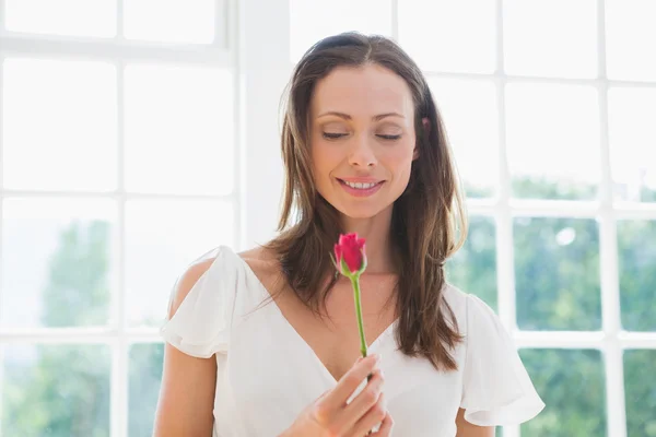 Thoughtful beautiful woman holding flower — Stock Photo, Image