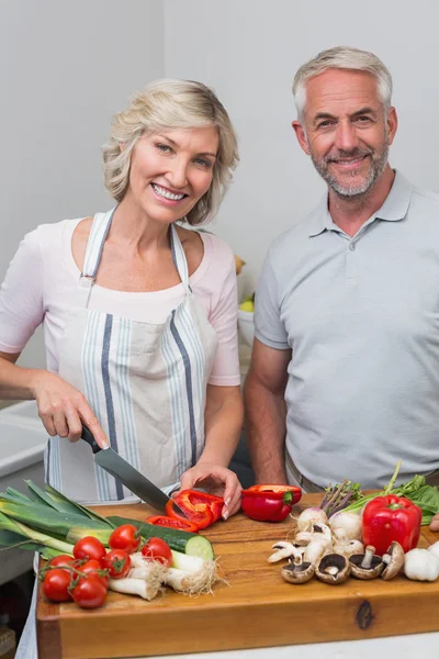 Happy mature couple preparing food in kitchen — Stock Photo, Image