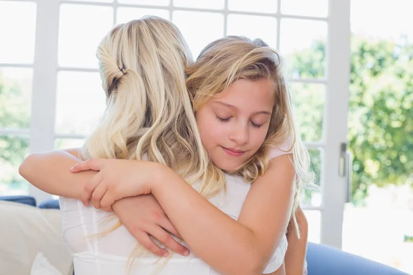 Girl with eyes closed hugging mother — Stock Photo, Image