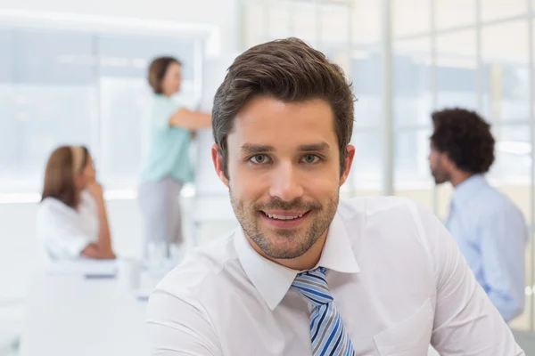 Lächelnder Geschäftsmann mit Kollegen bei Besprechung im Büro — Stockfoto