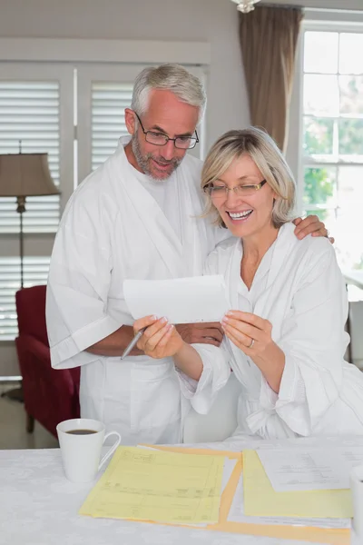 Mature couple looking at a document at home — Stock Photo, Image