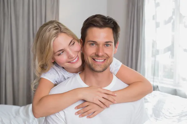 Loving woman embracing man from behind at home — Stock Photo, Image