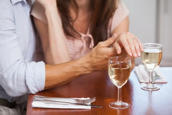 Media sezione di donna che mostra anello di fidanzamento con bicchieri di vino o — Foto Stock