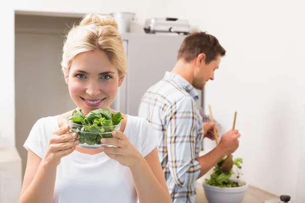 Жінка тримає миску листя з чоловіком готує салат — стокове фото