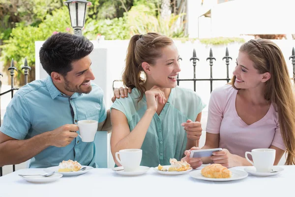 Happy friends reading text message in cafe — Stock Photo, Image