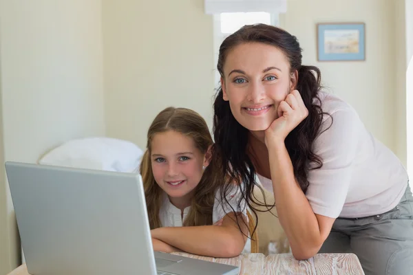 Madre e hija usando el ordenador portátil en casa —  Fotos de Stock