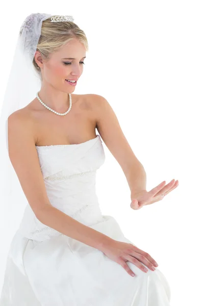 Невеста смотрит на обручальное кольцо на белом фоне — стоковое фото