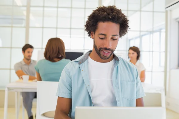 Uomo d'affari che utilizza computer portatile con i colleghi in riunione — Foto Stock