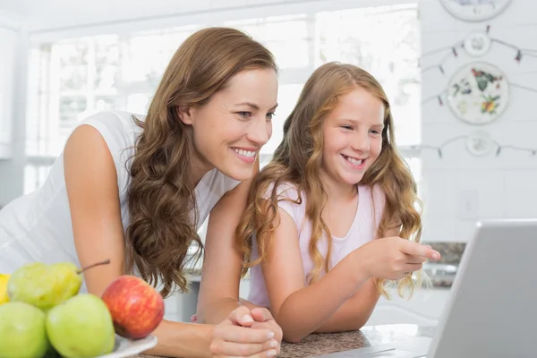 Mother and daughter using laptop in kitchen — Stock Photo, Image