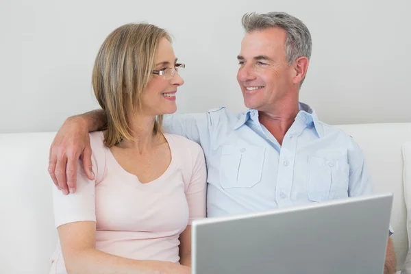 Entspanntes Paar nutzt Laptop zu Hause — Stockfoto