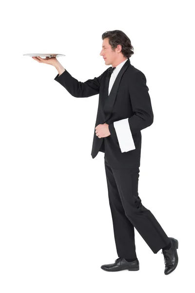 Waiter in suit carrying tray over white background — Stock Photo, Image