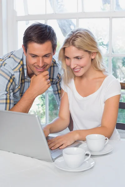 Coppia sorridente utilizzando il computer portatile a casa — Foto Stock