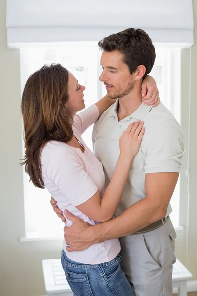 Loving man embracing woman at home — Stock Photo, Image