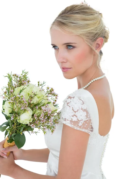 Mariée tenant bouquet de fleurs tout en regardant loin — Photo