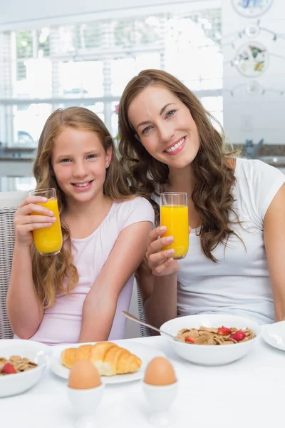 Mãe e filha tomando café da manhã na cozinha — Fotografia de Stock