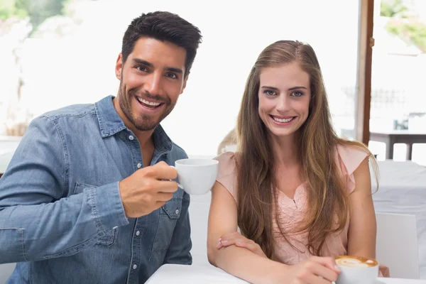 Улыбающаяся пара пьет кофе в кафе — стоковое фото