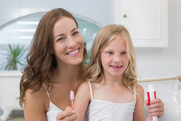 Madre e hija con cepillo de dientes y pasta de dientes — Foto de Stock