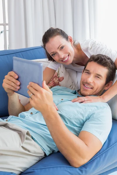 Milující pár s digitálním tabletu v obývacím pokoji — Stock fotografie
