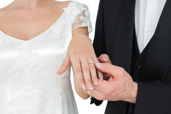 Novia y novio mostrando anillo de boda contra fondo blanco — Foto de Stock