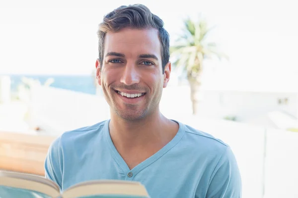 Portrait of a smiling man reading book — Stock Photo, Image